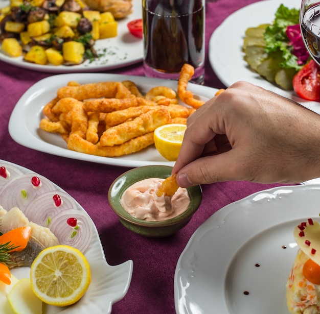 Immergendo lo spuntino croccante si attacca in salsa cremosa bianca.