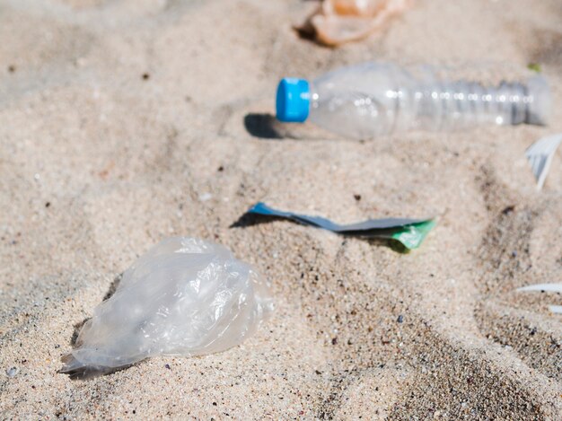 Immondizia di plastica residua sulla sabbia alla spiaggia