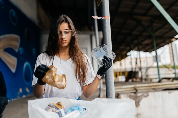 Immondizia di smistamento della giovane donna. Concetto di riciclaggio. Zero sprechi