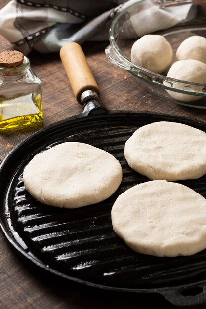 Impasto di arepas ad alto angolo sulla bistecchiera