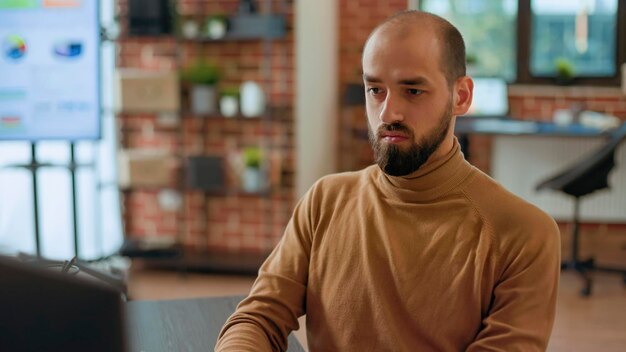 Impiegato aziendale che lavora con statistiche e grafici finanziari sul computer, guardando documenti con piano di progetto. Imprenditore professionista che analizza la strategia di gestione per la crescita dell'azienda.