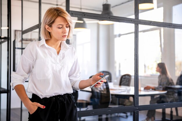 Impiegato corporativo di vista frontale che esamina telefono