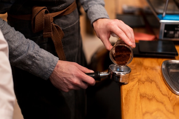 Impiegato della caffetteria che produce caffè