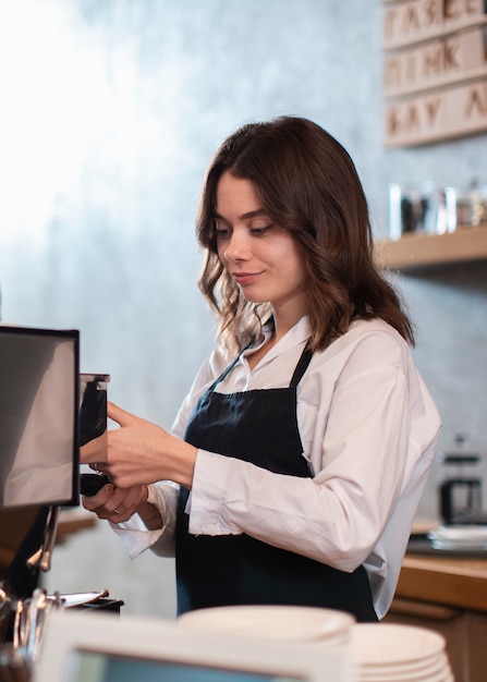 Impiegato femminile che produce caffè