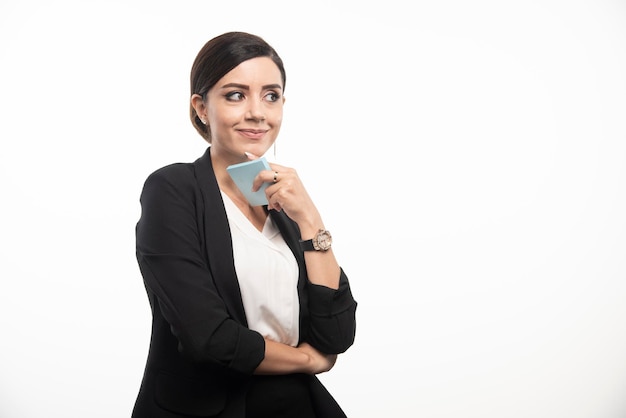 Impiegato femminile che tiene il blocco note su priorità bassa bianca. Foto di alta qualità