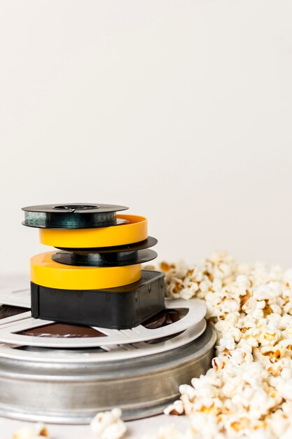 Impilati di bobine di film con popcorn contro sfondo bianco