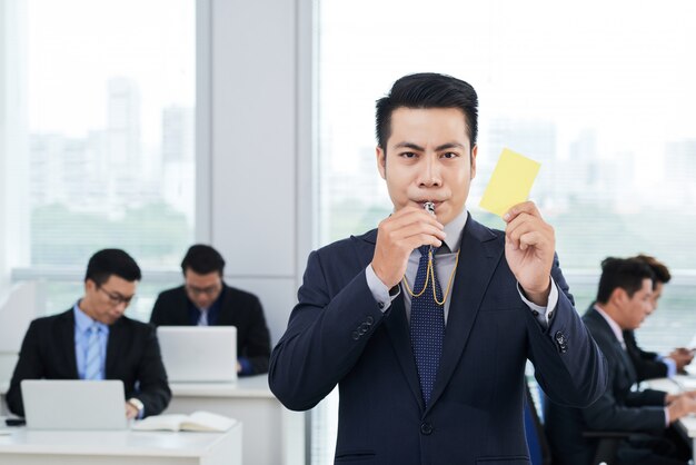 Imprenditore asiatico che mostra cartellino giallo