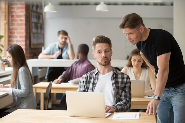 Imprenditore casuale che spiega il progetto di affari al suo collega.