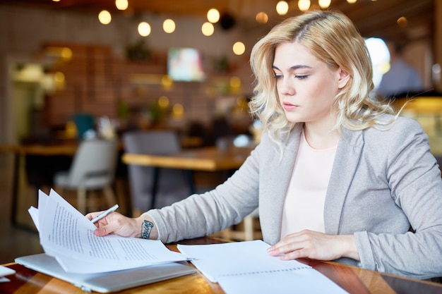 Imprenditore grazioso che lavora dal caffè