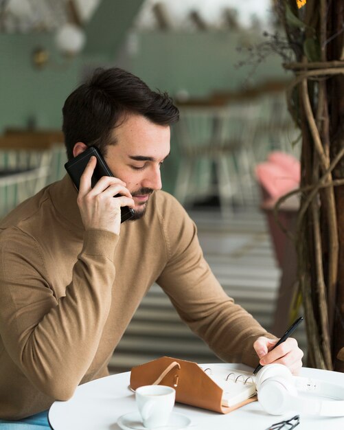 Imprenditore maschio di vista laterale che parla sopra il telefono