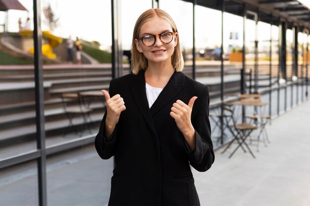 Imprenditrice di smiley utilizzando il linguaggio dei segni all'aperto al lavoro