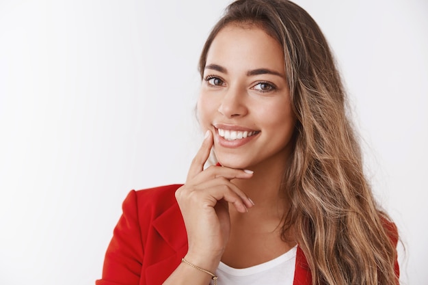 Imprenditrice femminile di successo spensierata che tiene una lezione su come diventare una donna d'affari sicura di sé sorridente ampiamente sicura di sé toccando la mascella guardando la telecamera inclinando la testa sorridendo denti bianchi felici