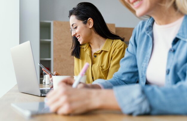 Imprenditrice prendendo appunti accanto al suo collega