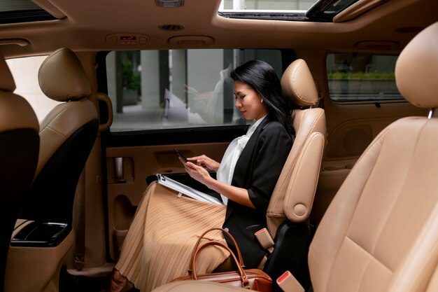 Imprenditrice seduta sul sedile posteriore di un taxi