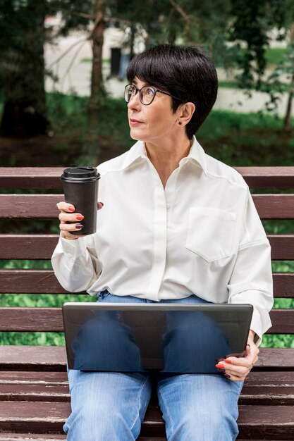 Imprenditrice tenendo una tazza di caffè e guardando lontano