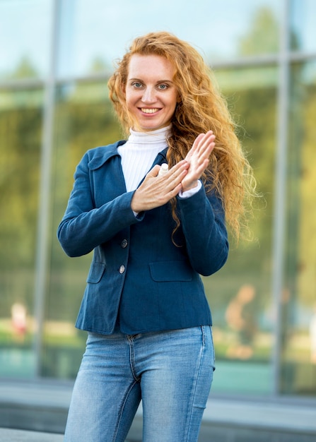 Imprenditrice utilizzando disinfettante per le mani vista frontale