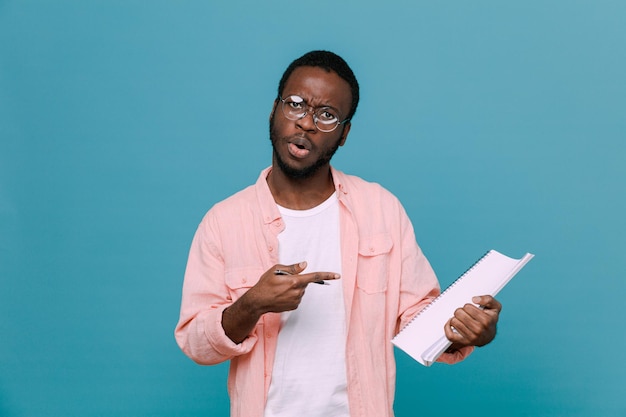 impressionato azienda e punti a carta giovane ragazzo afroamericano isolato su sfondo blu