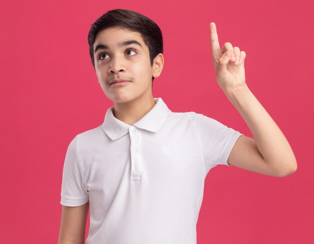 Impressionato giovane ragazzo caucasico guardando il lato rivolto verso l'alto