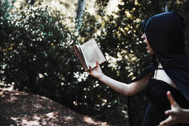 Incantesimo della lettura del mago femminile in boschetto