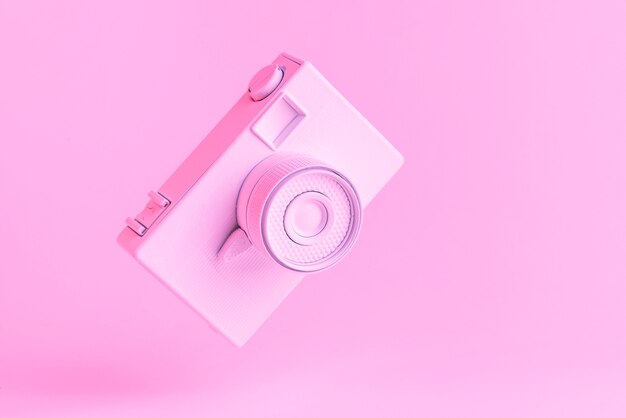 Inclinare la macchina fotografica d&#39;epoca su sfondo rosa