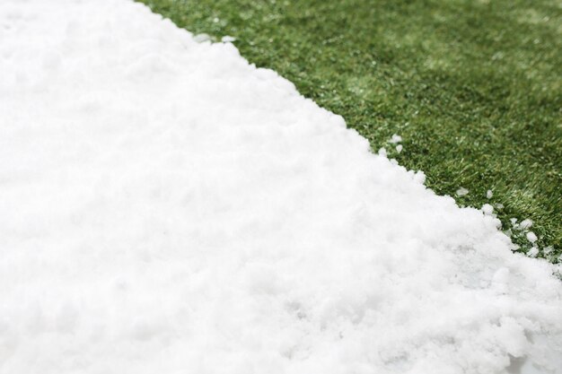 Incontro con la neve bianca e l'erba verde da vicino. tra l'inverno e la primavera sfondo del concetto.