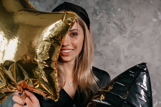 Incredibile donna con capelli biondi e un sorriso affascinante che copre il viso