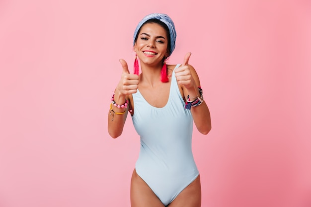 Incredibile donna in costume da bagno che mostra i pollici in su