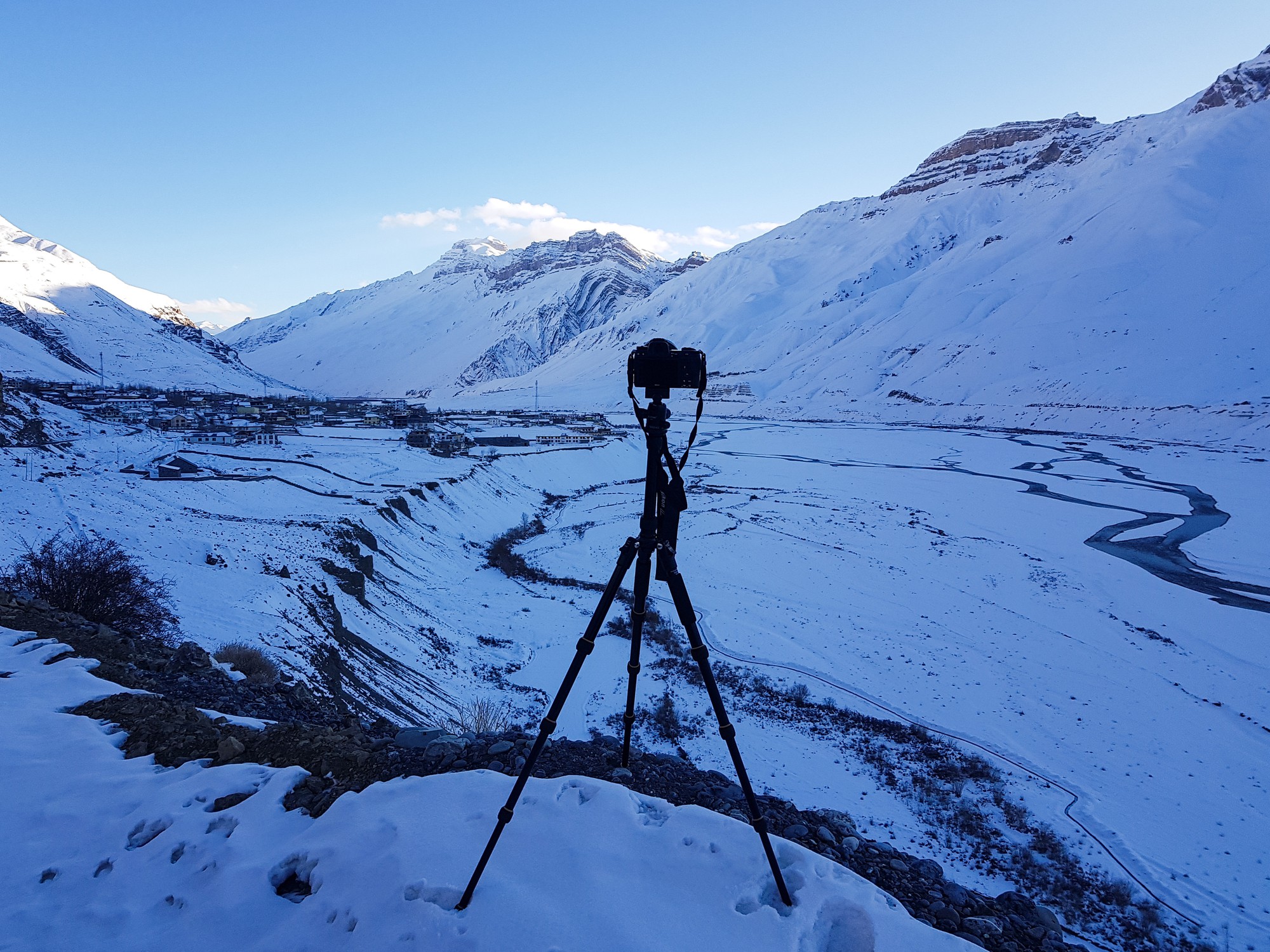 Incredibile scatto di una catena montuosa ricoperta di neve su un supporto per fotocamera in primo piano