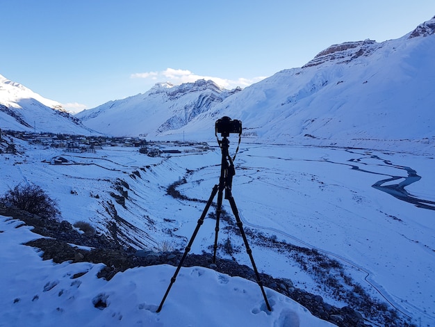 Incredibile scatto di una catena montuosa ricoperta di neve su un supporto per fotocamera in primo piano