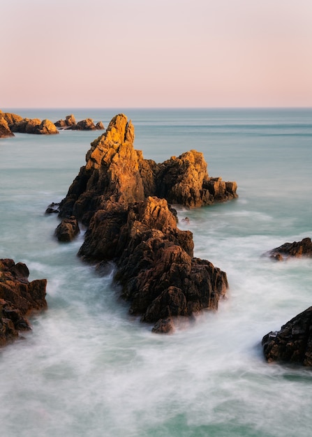 Incredibile scatto di una spiaggia rocciosa su uno sfondo tramonto