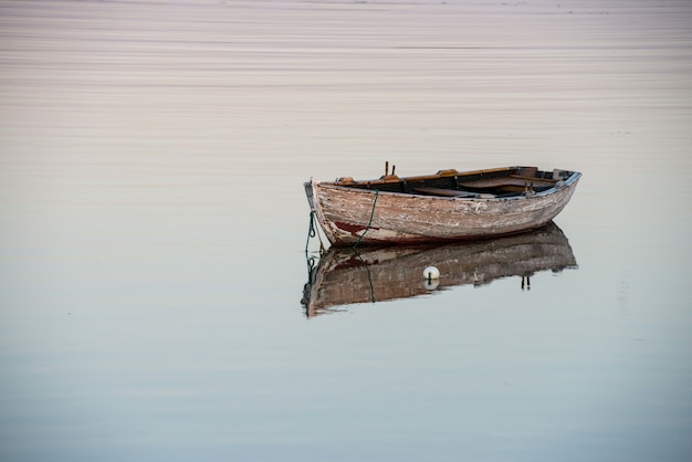 Incredibile scatto di una vecchia barca di legno su un lago riflettente