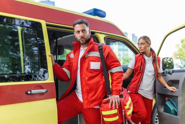 Infermiere paramedico e medico di emergenza in ambulanza con kit un paramedico in piedi sul retro di un'ambulanza vicino alle porte aperte