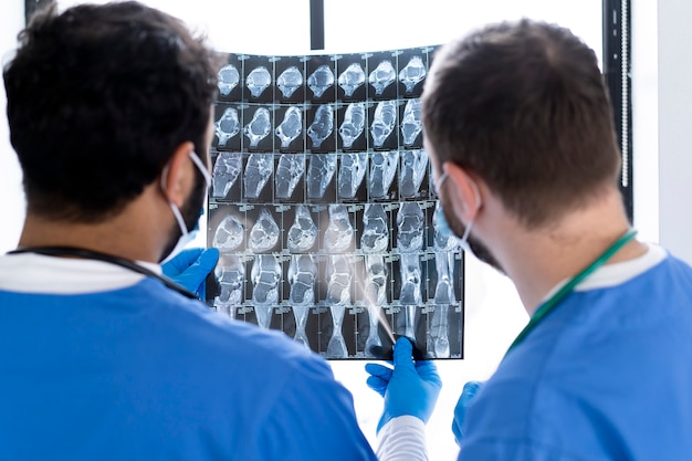 Infermieri di vista posteriore che esaminano la radiografia