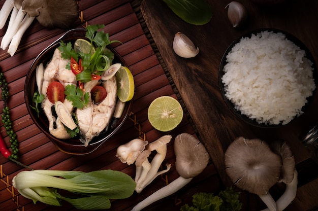 Infuso di pesce bollito con pomodori, funghi, coriandolo, cipollotto e citronella in una ciotola