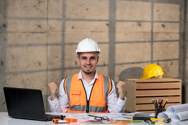 Ingegnere bel giovane ragazzo intelligente lavoratore civile in casco e giubbotto molto felice