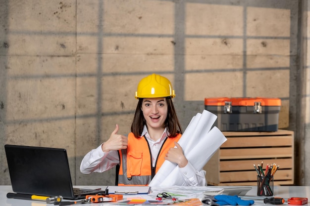 Ingegnere carino giovane ragazza bruna intelligente lavoratore civile in casco e gilet molto felice