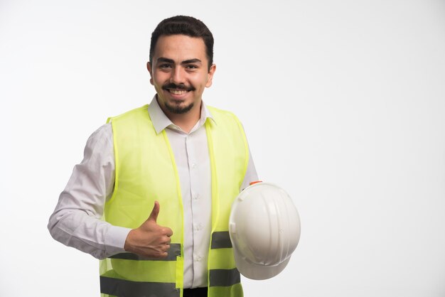 Ingegnere in uniforme che tiene un casco bianco.