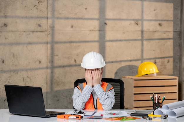 Ingegnere intelligente giovane ragazza bionda carina lavoratore civile in casco e giubbotto che copre il viso