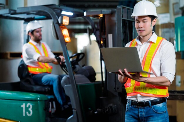 Ingegnere personale magazziniere maschio in elmetto che lavora a piedi attraverso il centro logistico magazzino fabbrica cantiere logistica architetto forklife driver uomo costruttore interni sfondo