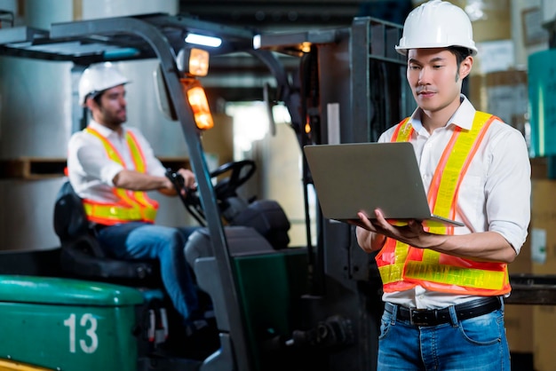 Ingegnere personale magazziniere maschio in elmetto che lavora a piedi attraverso il centro logistico magazzino fabbrica cantiere logistica architetto forklife driver uomo costruttore interni sfondo