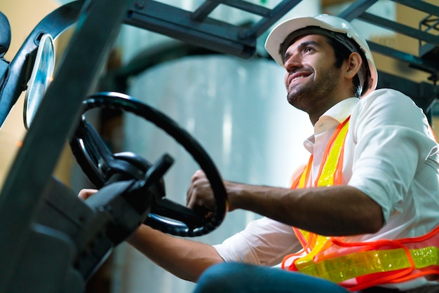 Ingegnere personale magazziniere maschio in elmetto che lavora a piedi attraverso il centro logistico magazzino fabbrica cantiere logistica architetto forklife driver uomo costruttore interni sfondo