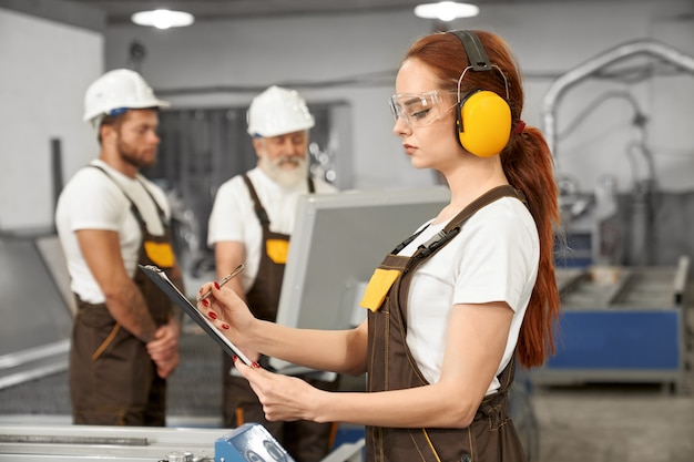 Ingegneri che lavorano con la taglierina laser al plasma in fabbrica.