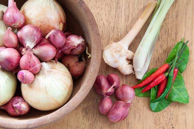 Ingrediente alimentare caldo e speziato asiatico con cipolle in ciotola di legno, piano lay, vista dall&#39;alto