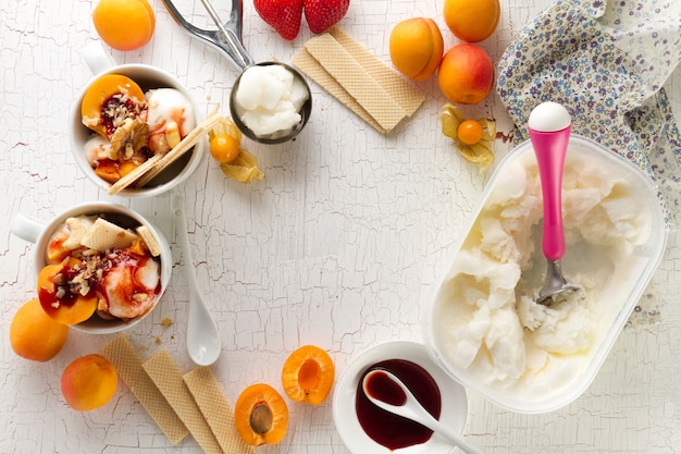 Ingredienti appetitosi saporiti per la cottura di gelato alla vaniglia con spoon e frutta di gelato. Vista superiore con lo spazio di copia.