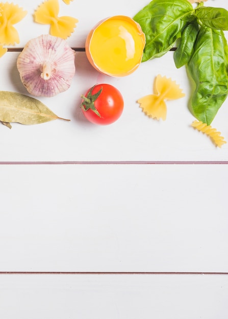 Ingredienti della pasta su fondo di legno bianco