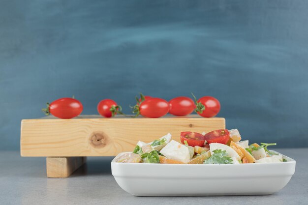 Ingredienti misti insalata di frutta e verdura in una tazza bianca.