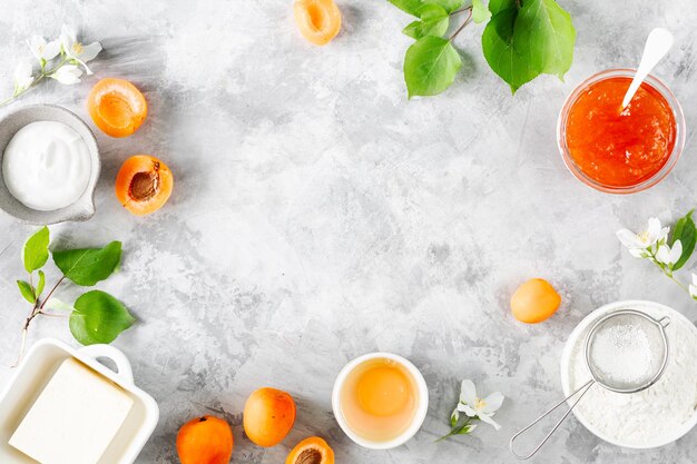 Ingredienti per cuocere una torta di pasta frolla con albicocche Burro zucchero uova marmellata di albicocche Vista dall'alto Copia spazio