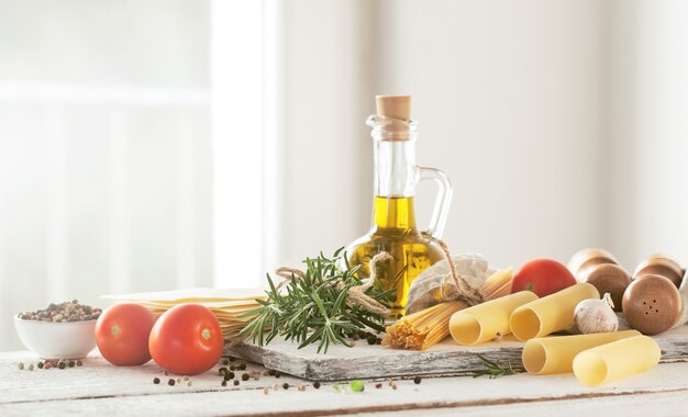 Ingredienti per fare la pasta, con olio e pomodoro