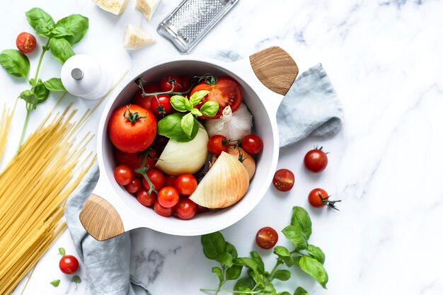 Ingredienti per pasta biologica e verdure in una pentola di ceramica