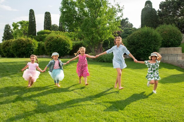 Inizio divertente. Concetto di moda per bambini. Il gruppo di ragazzi e ragazze adolescenti che corrono al parco. Bambini vestiti colorati, stile di vita, concetti di colori alla moda.